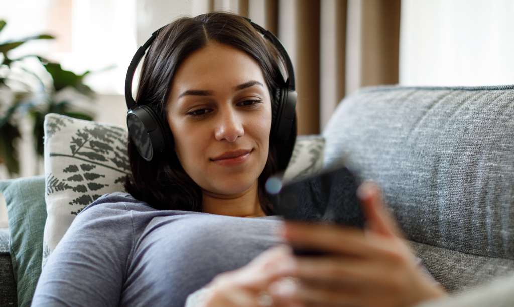 woman on sofa looking at her phone